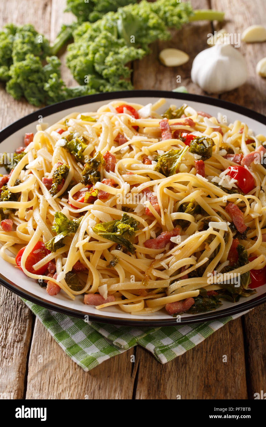 Italian lunch of pasta with cabbage kale, bacon, tomatoes and parmesan