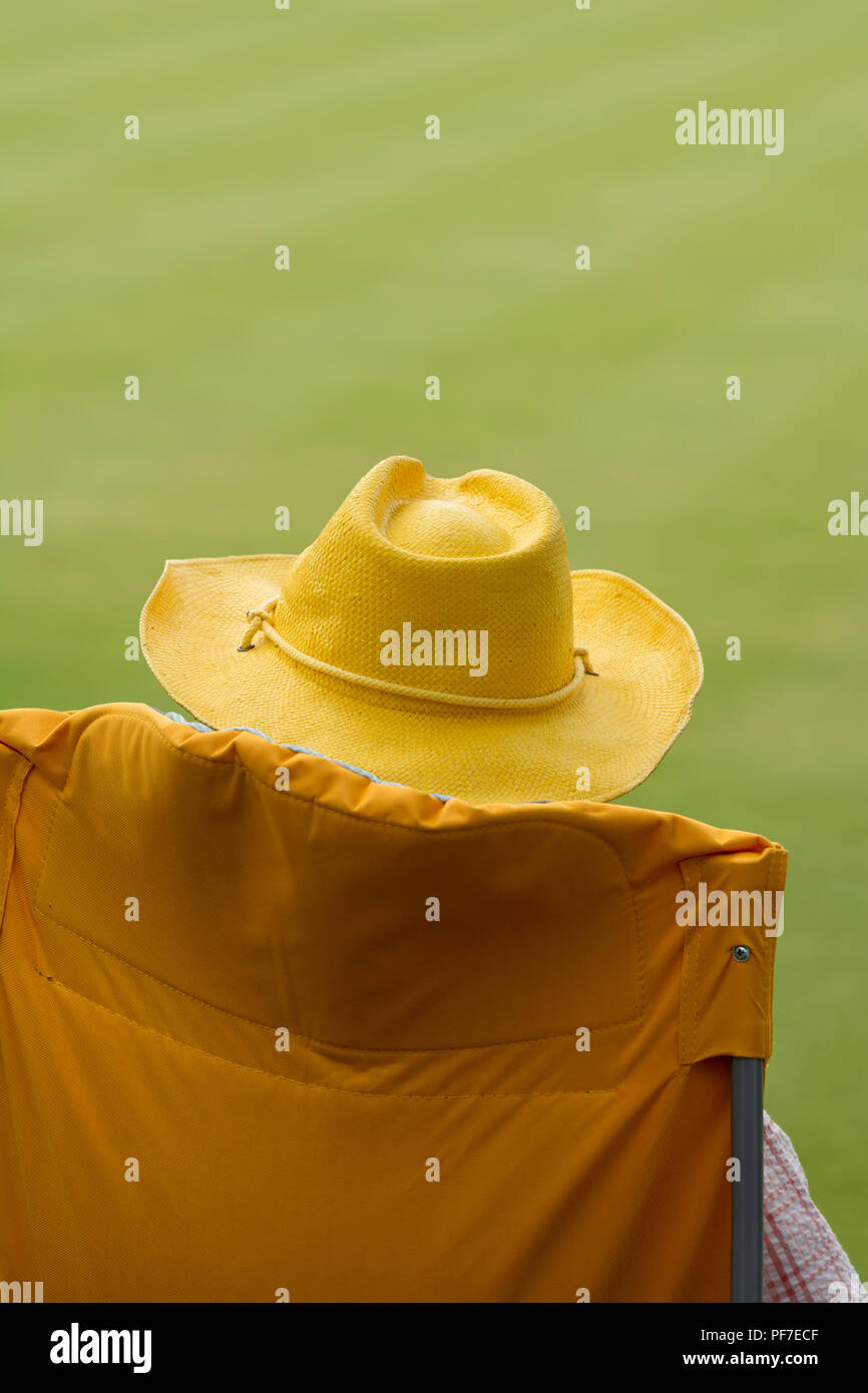 A man in a yellow hat sitting in a yellow chair Stock Photo - Alamy