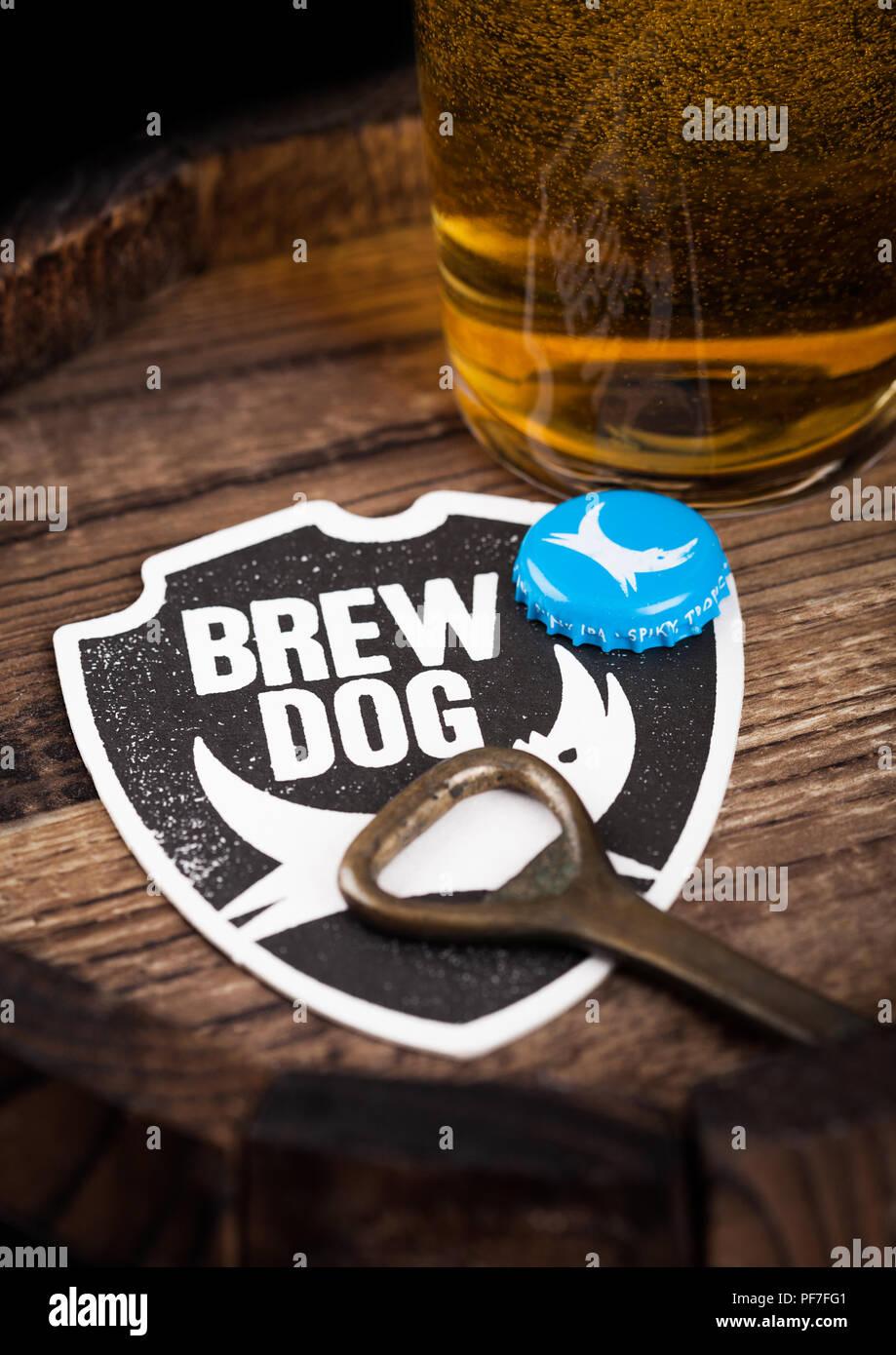 LONDON, UK - AUGUST 10, 2018: Brewdog beer coaster with bottle top and opener and glass of beer on top of wood barrel. Stock Photo