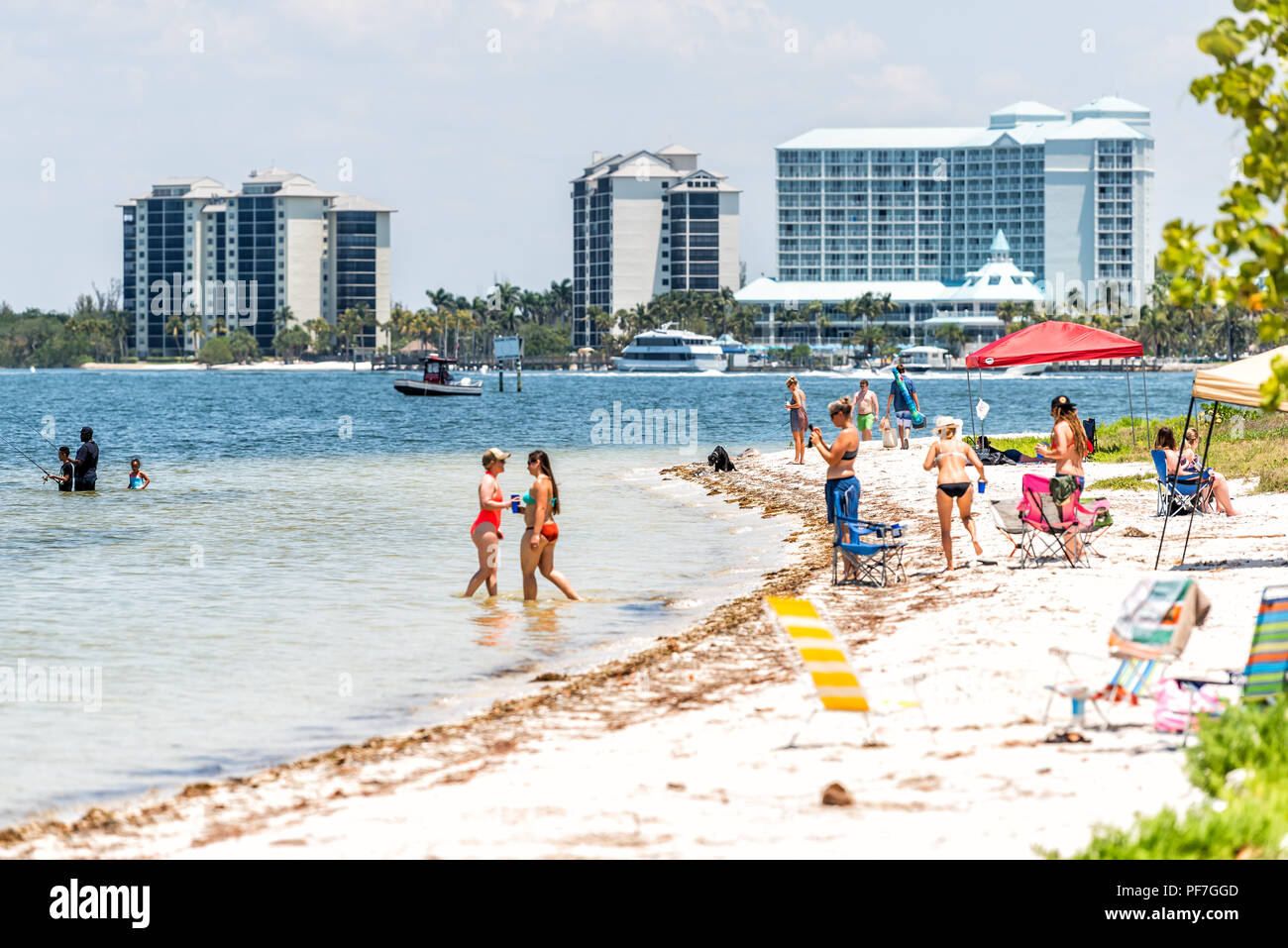 Sanibel Island, USA - April 29, 2018: Causeway beach with many people, tourists, crowd, crowded coast, coastline, chairs during sunny day Stock Photo