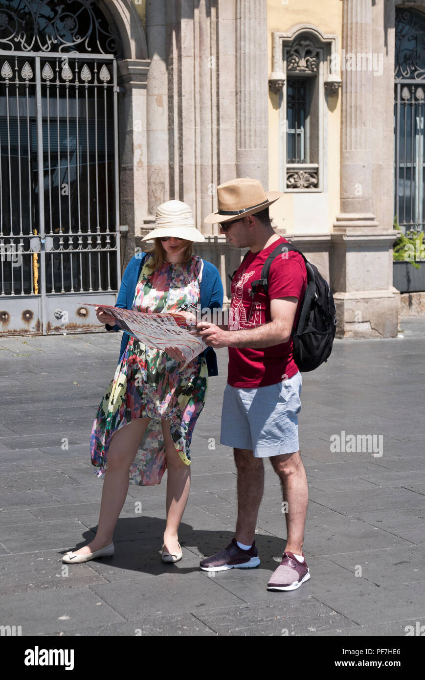 A couple in casual clothes looking at a handhold map, Barcelona, Spain Stock Photo