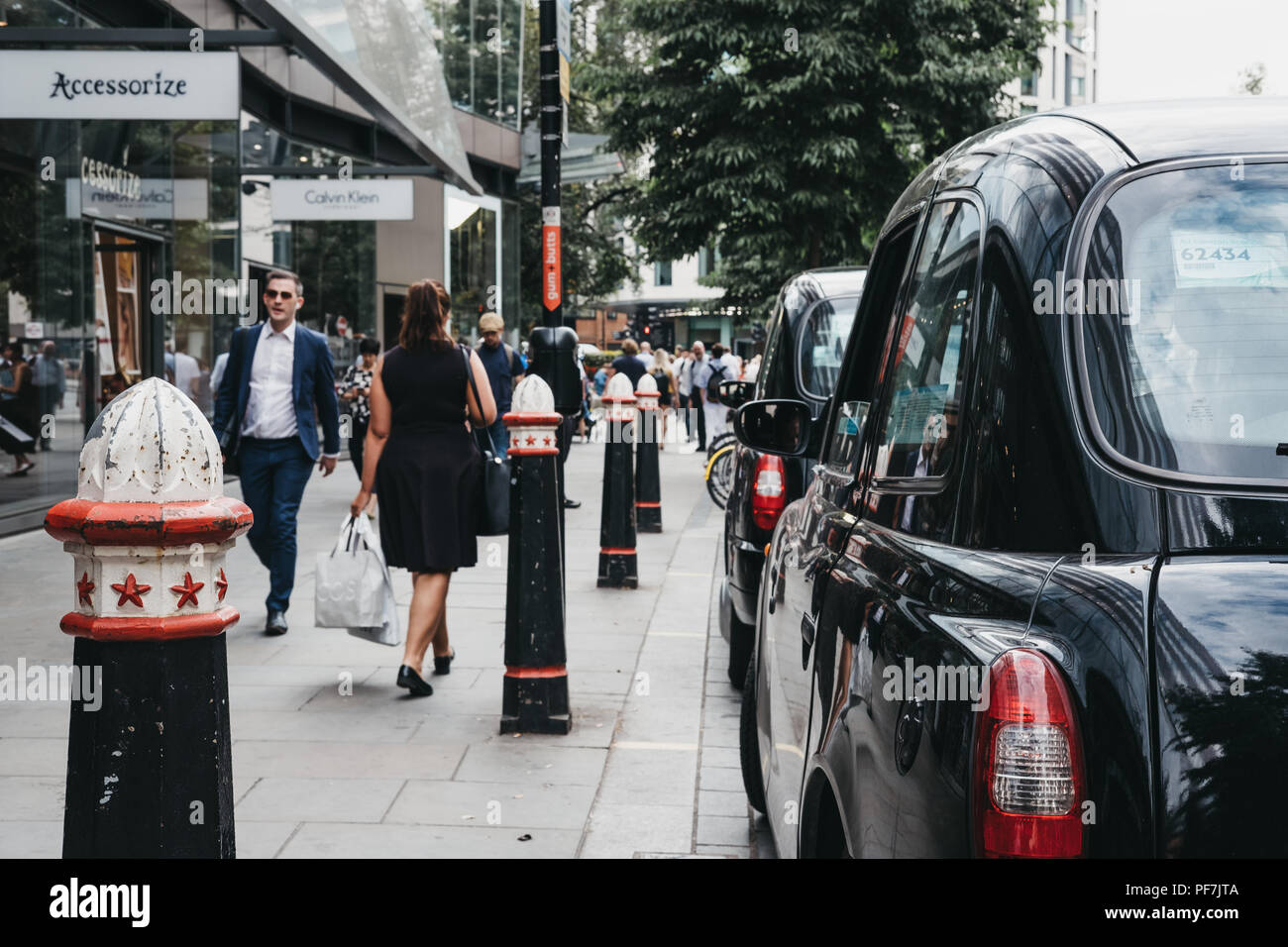 Row of Black cabs parked on a side of the road in City of London, London's famous financial district. Stock Photo
