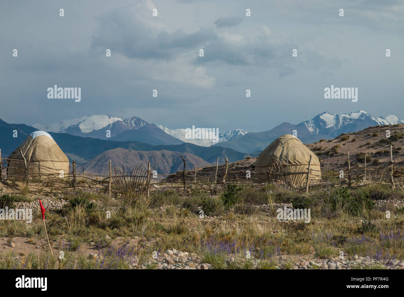 Traditional Kyrgyz yurts with snow capped mountains in the background. Near Bokonbayevo, Kyrgyzstan. Stock Photo