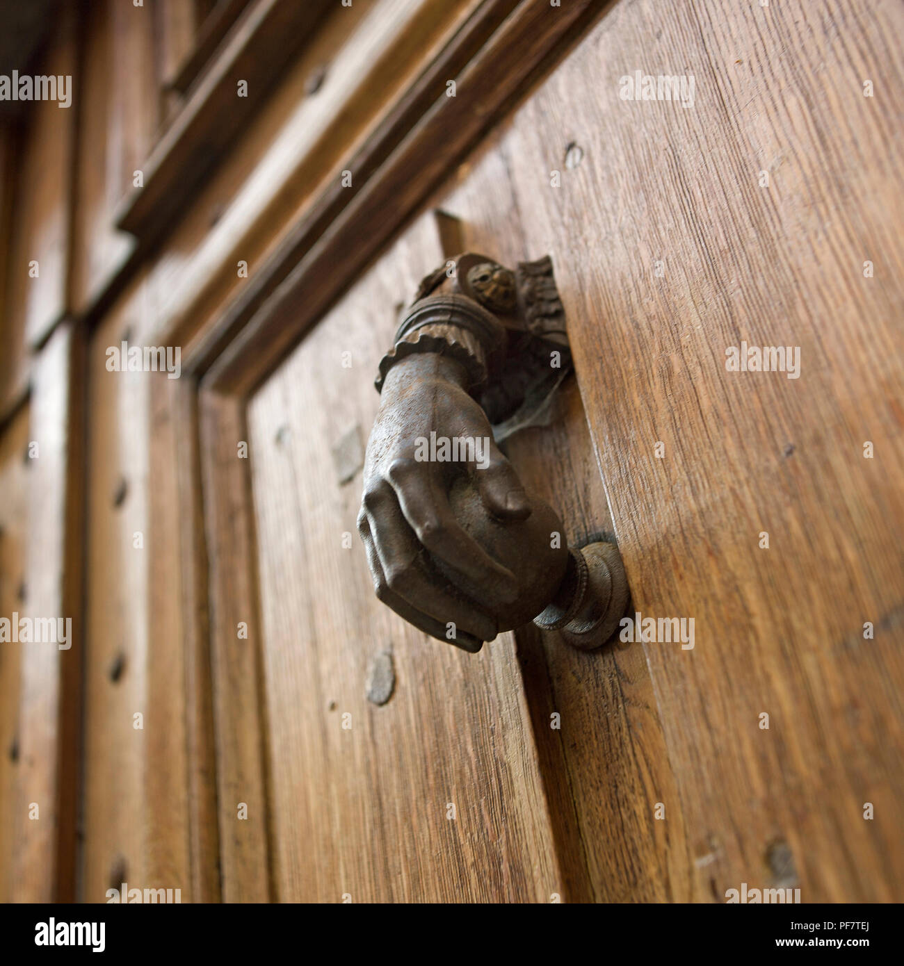 Low angle closeup shot of a hand-shaped doorknob on a wooden door Stock Photo