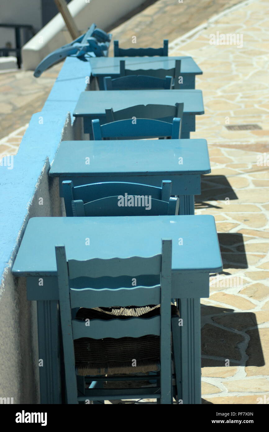 'The traditional and quiet Greek island of Anafi. A row of old fashioned taverna tables painted blue' Stock Photo