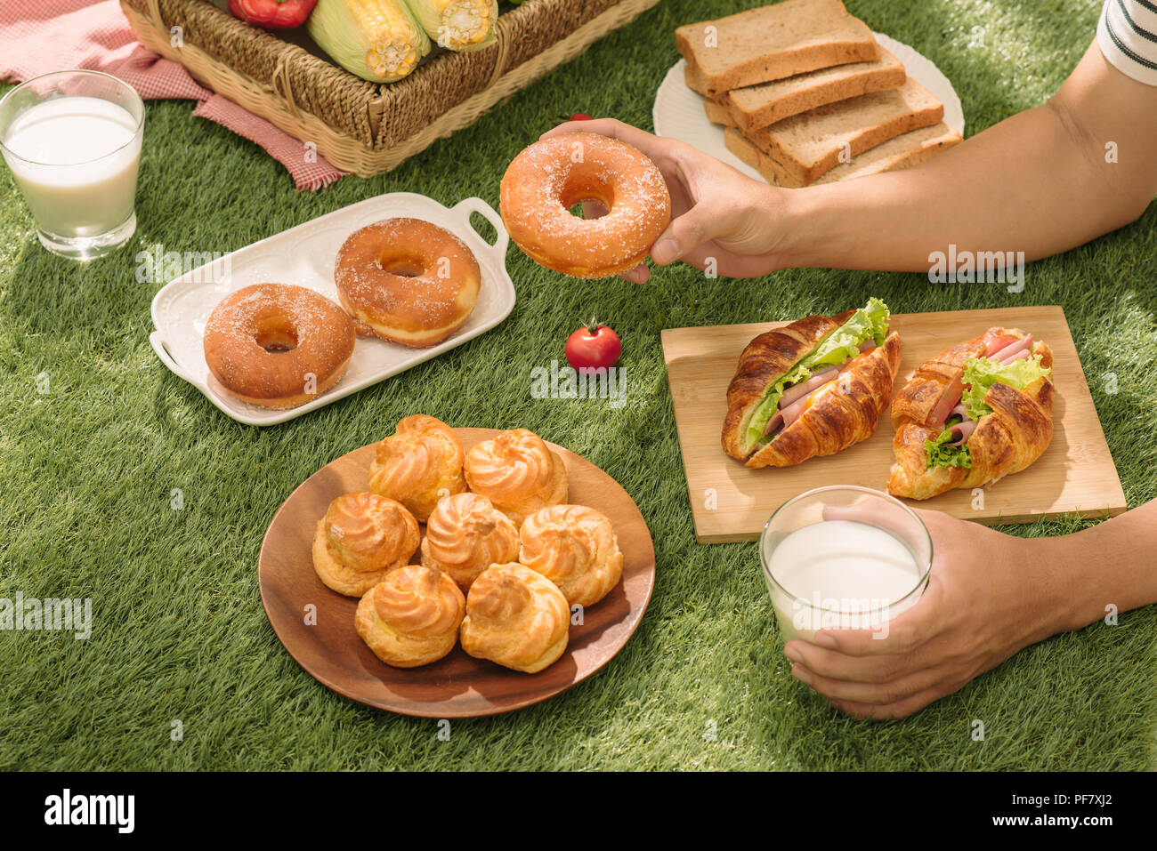 Picnic wicker basket with food, bread, fruit and orange juice on a red ...