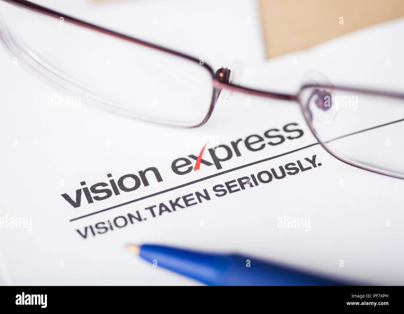 LONDON, UK - AUGUST 18, 2018: Vision Express Logo on papre with glasses and pen. Stock Photo