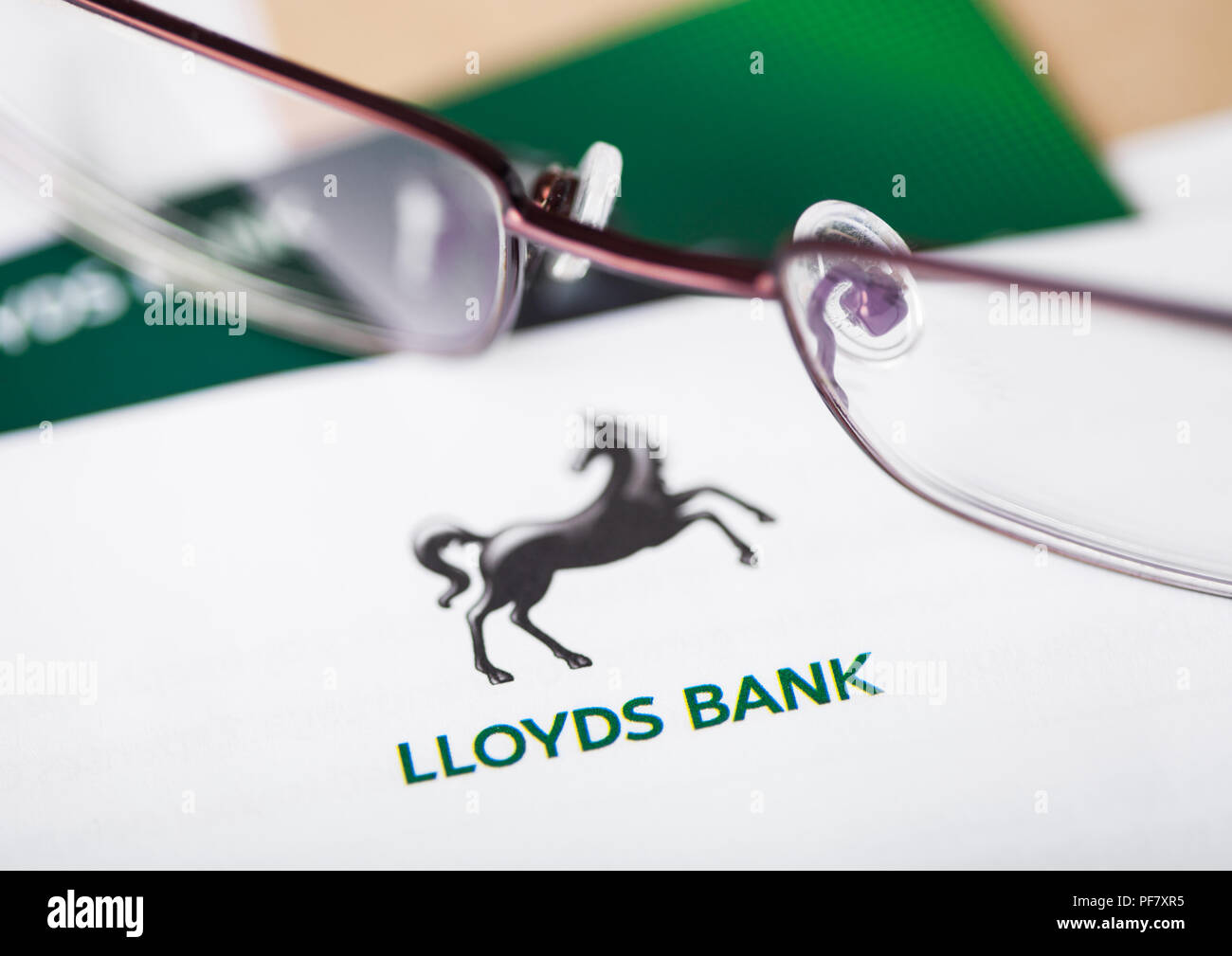 LONDON, UK - AUGUST 18, 2018: Lloyds Banking Group statement and credit card with glasses. Stock Photo