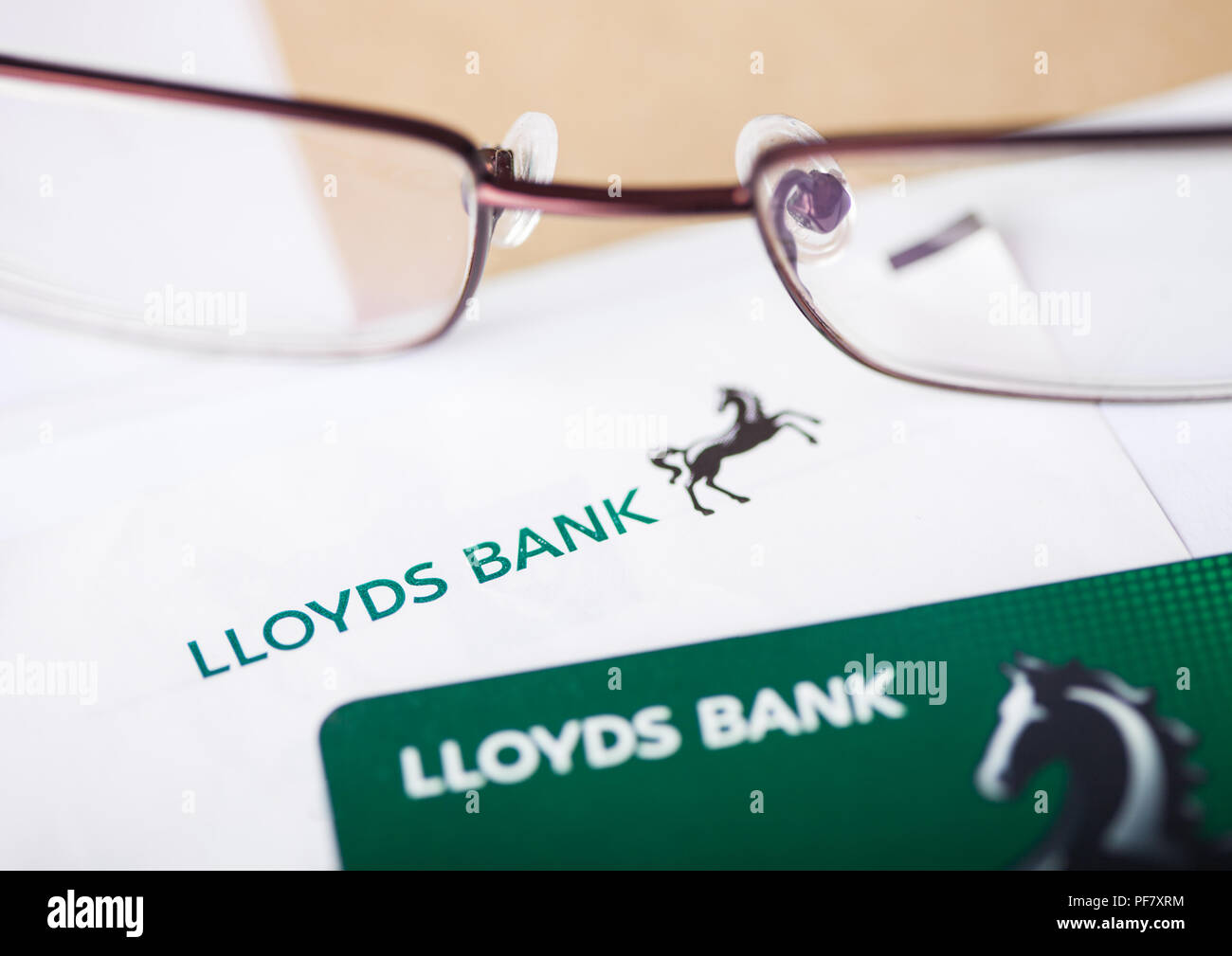 LONDON, UK - AUGUST 18, 2018: Lloyds Banking Group statement and credit card with glasses. Stock Photo