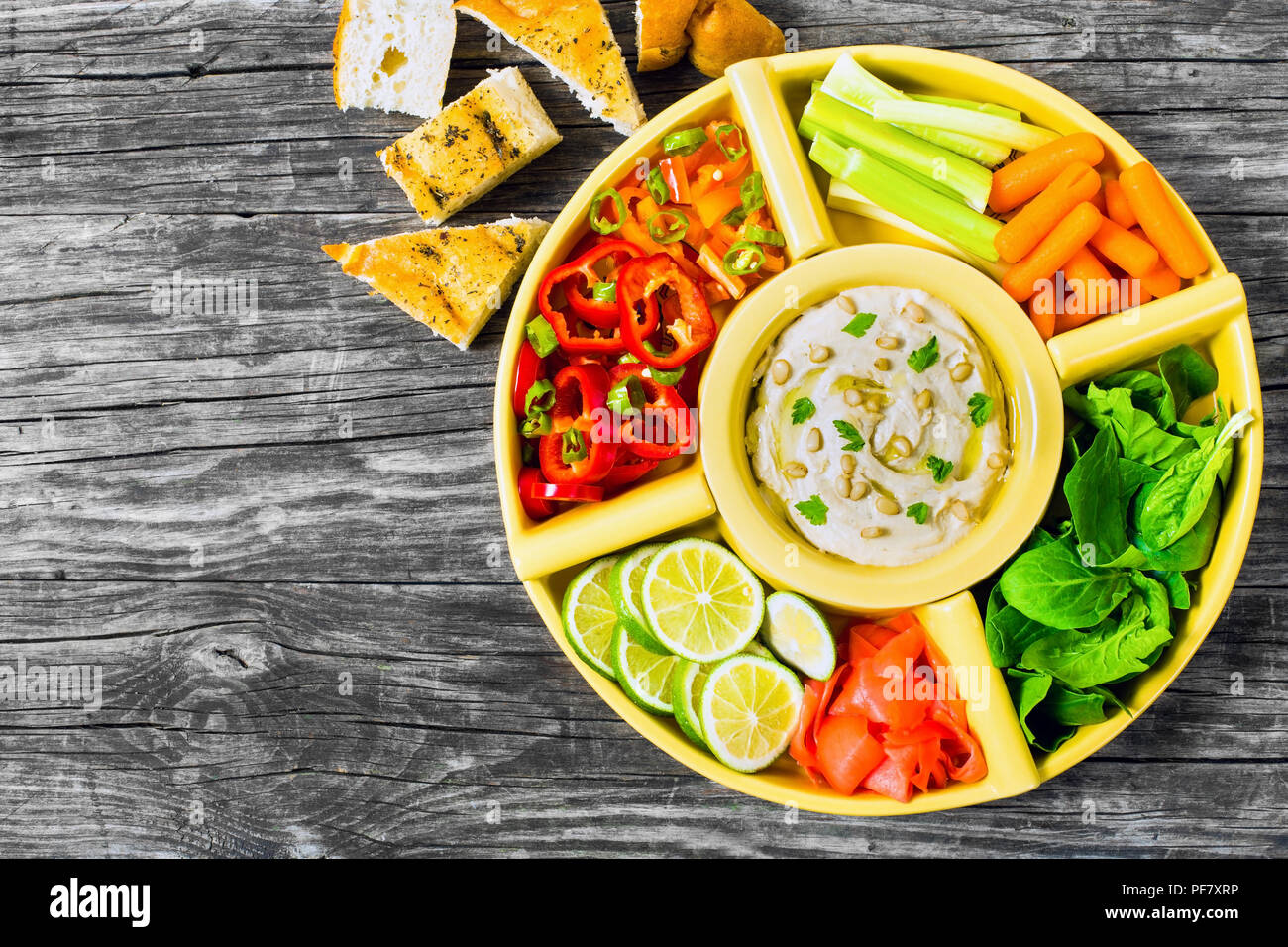 hummus, carrots, celery sticks, spinach, ginger, sliced lime, olive oil