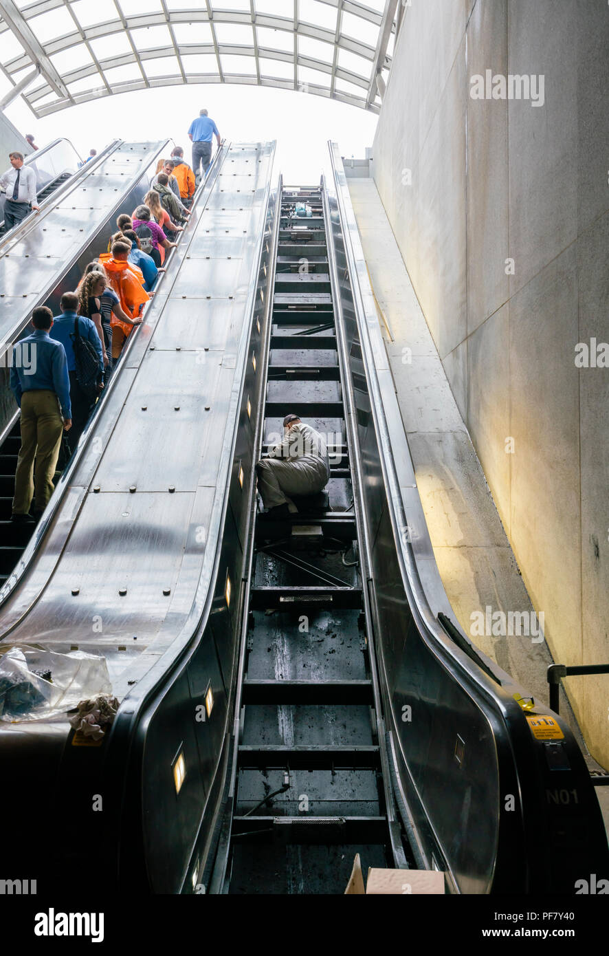 Worker repairing an escalator in a train station Stock Photo