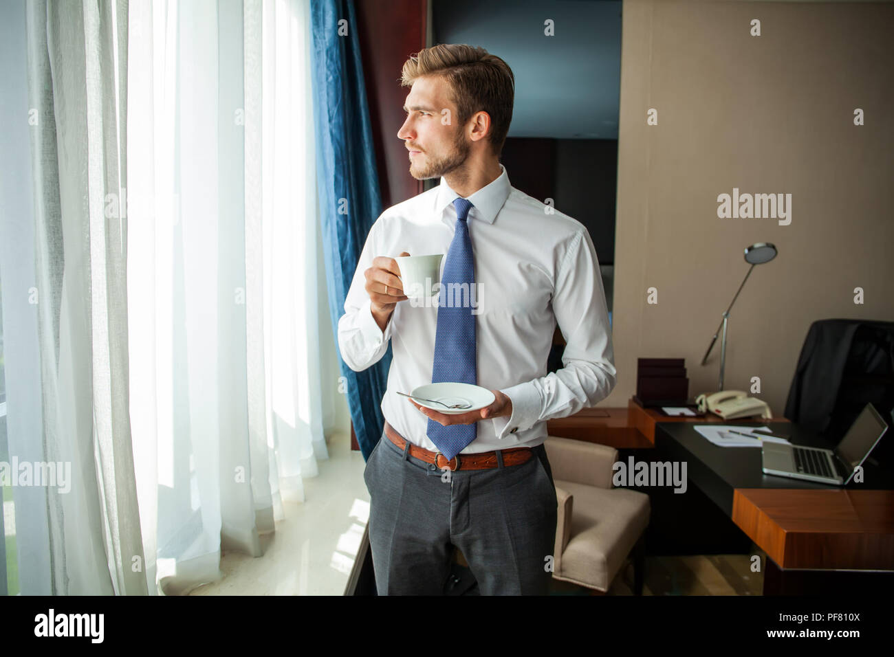 business trip and people concept businessman drinking coffee at hotel