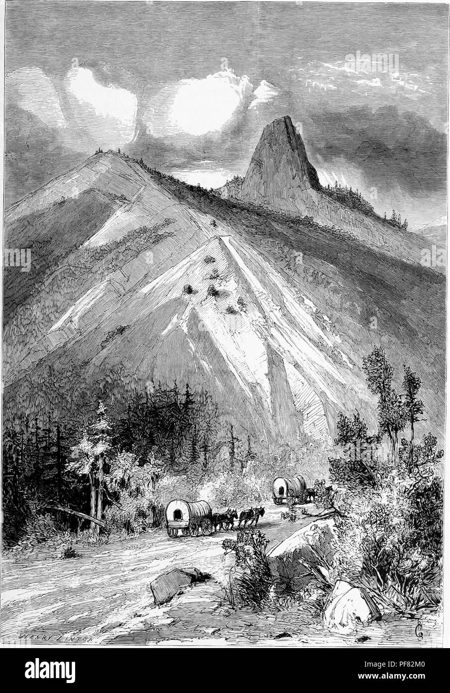 Black and white vintage print depicting several covered wagons navigating a dirt road, with the Pilot Knob peak or volcanic plug in the background, located in Imperial County, California, USA, published in William Cullen Bryant's edited volume 'Picturesque America; or, The Land We Live In', 1872. Courtesy Internet Archive. () Stock Photo