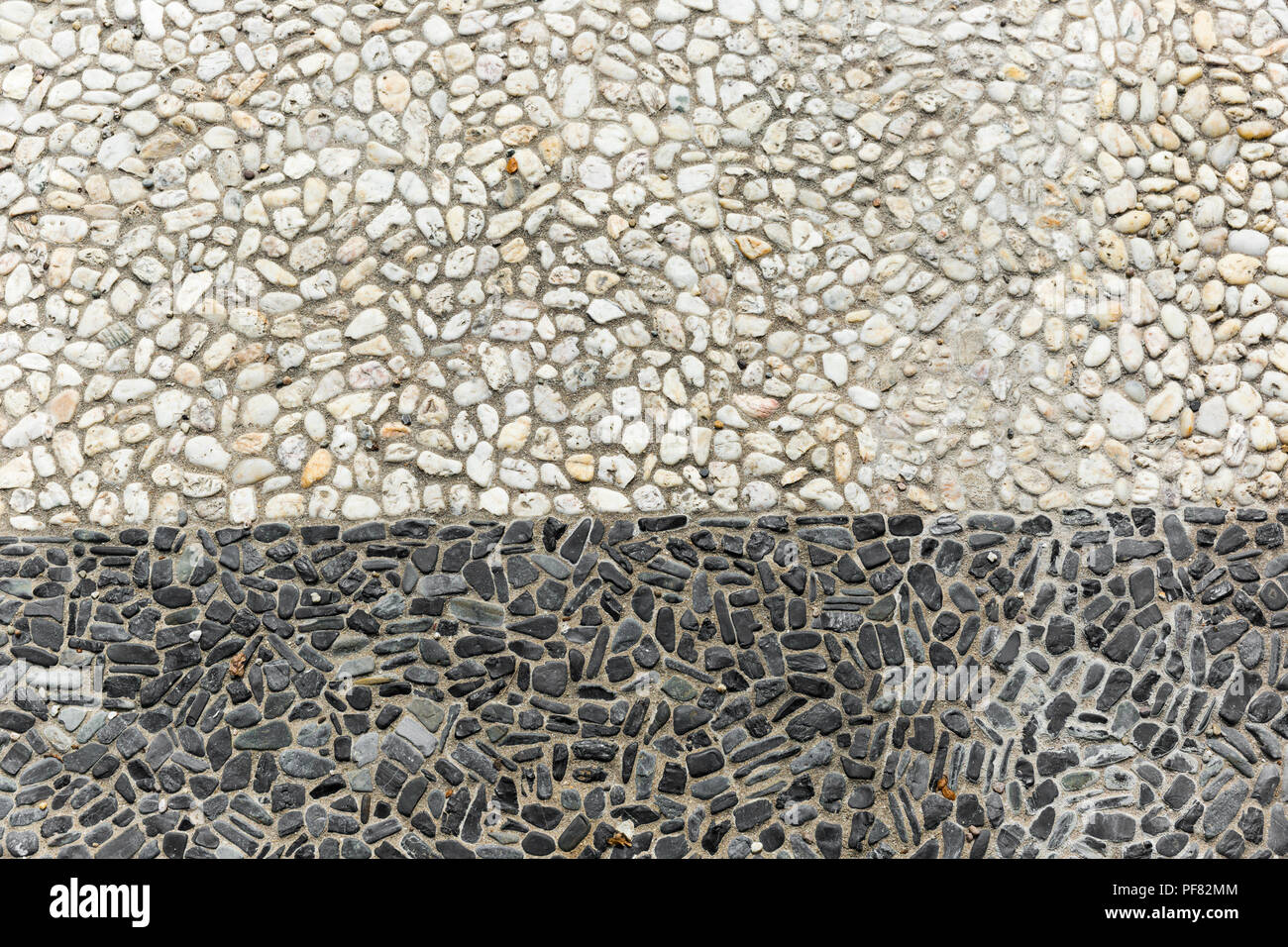 Stones and pebbles mixed together with a definite line through the center. Stock Photo