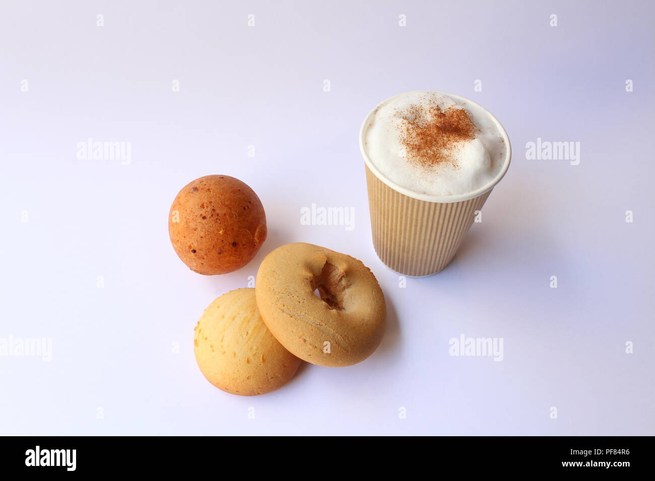 Take away capuccino coffee with some traditional colombian pastries, usually served for breakfast. Almojabana, buñuelo and pandebono. Stock Photo