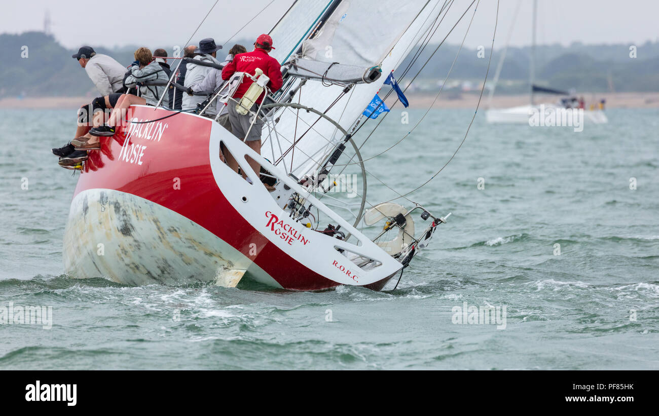 The Solent, Hampshire, UK; 7th August 2018; View To Stern of Yacht Heeled at Extreme Angle Whilst Racing at Cowes Week Regatta. Crew at Side of Boat Stock Photo