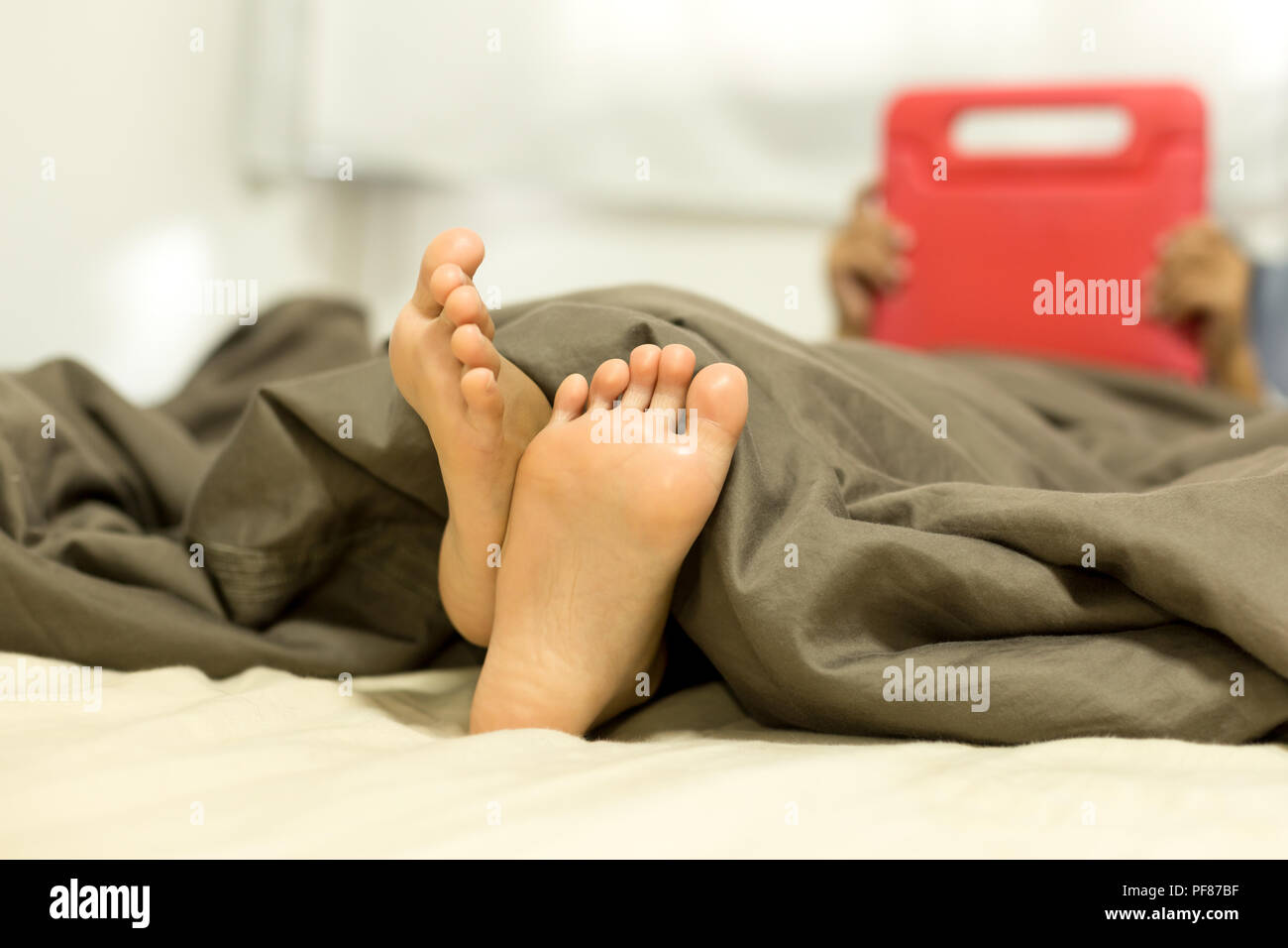 Little child bare feet lying in bed while playing game happy time Stock  Photo - Alamy