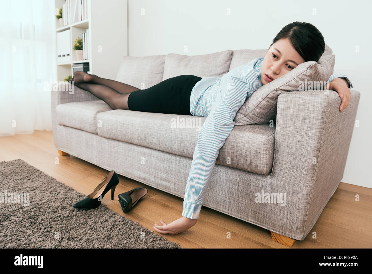 she got the blow from work and lie down on the soft feel frustration at home Stock Photo