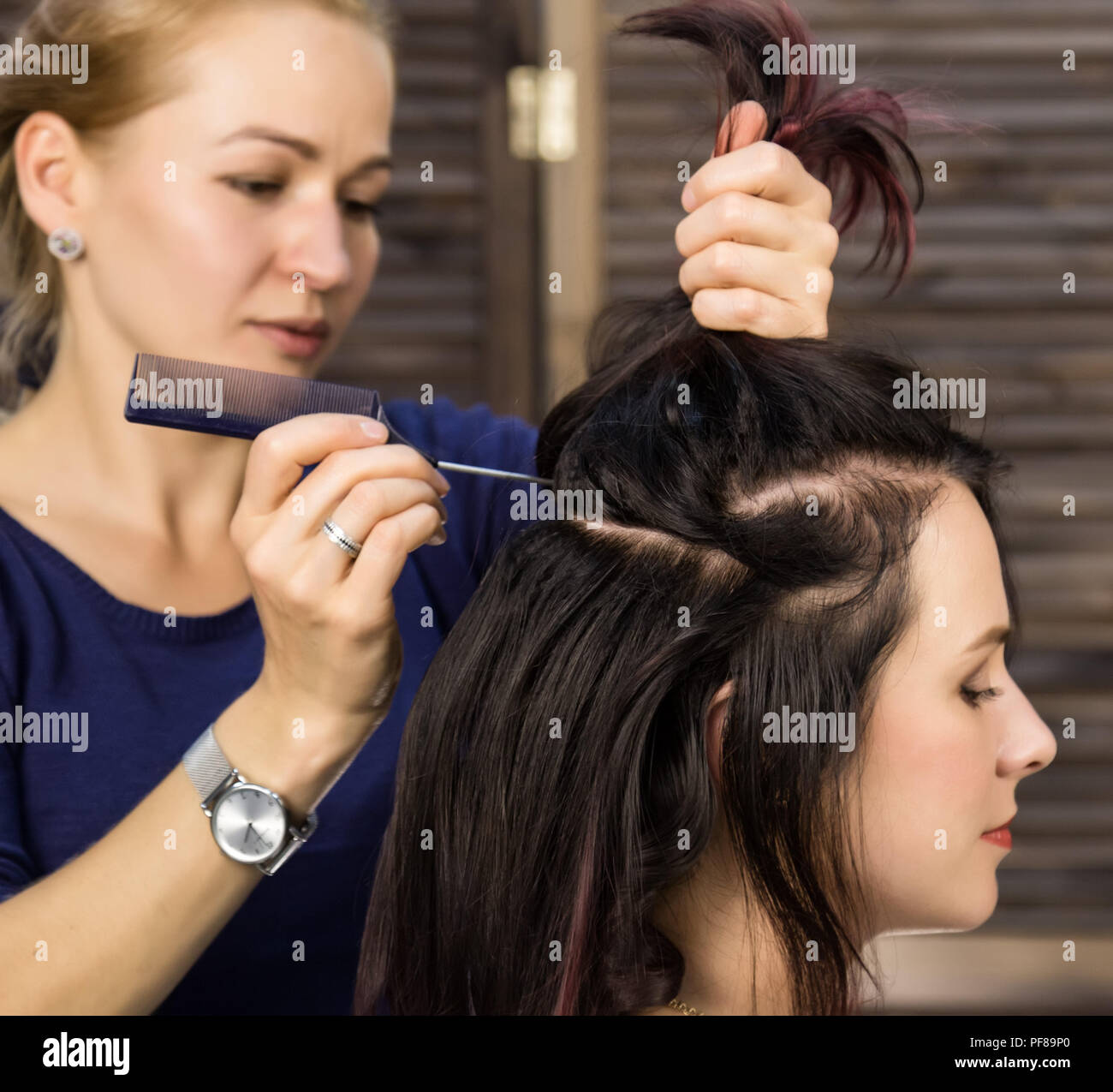 Hairdresser does hairstyle for luxurious woman. coiffure in the form of