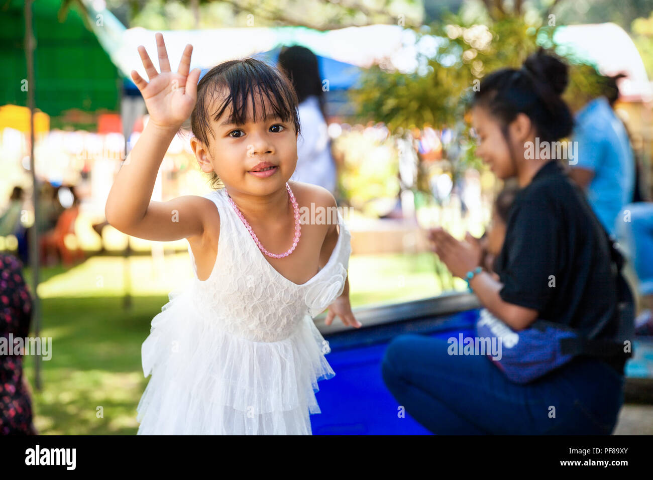 Authentic photo young happy asian baby girl in dress funny posing for a photosession Stock Photo
