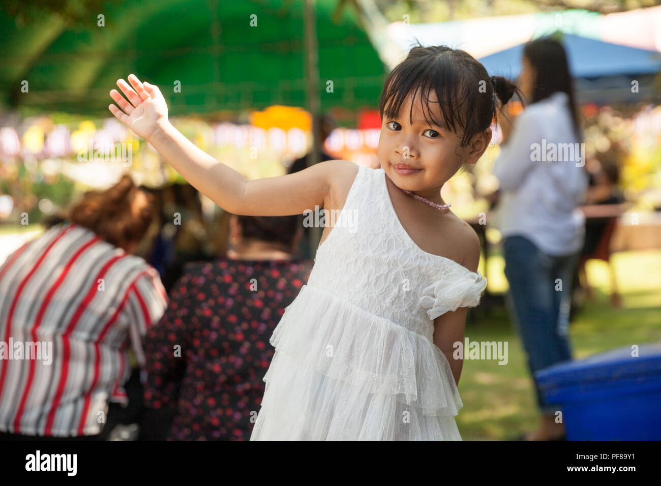 Authentic photo young happy asian baby girl in dress funny posing for a photosession Stock Photo