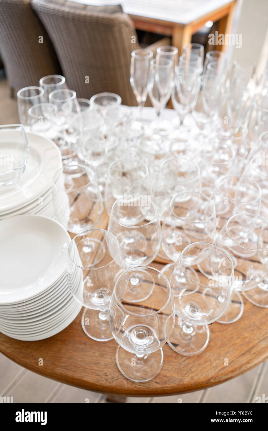 Clean plates, glasses and cutlery on wooden table. Catering setup