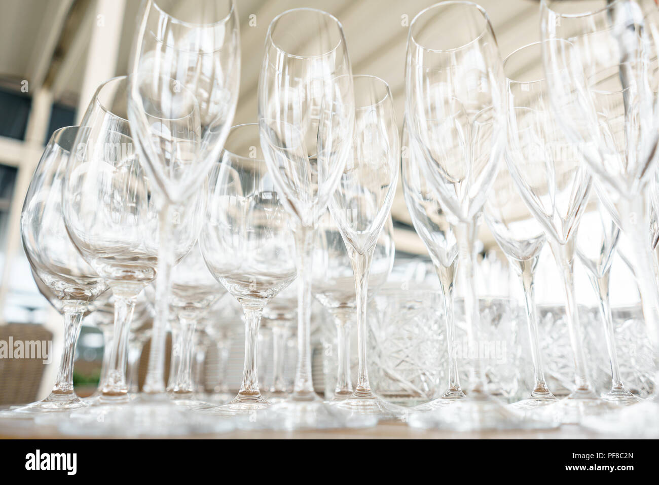 Clean plates, glasses and cutlery on wooden table. Catering setup