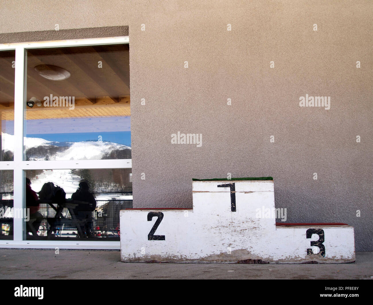 Old-fashioned and damaged podium along a wall in a winter sports resort. France Stock Photo
