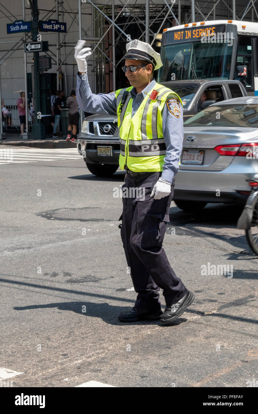 A New York City traffic cop directing traffic on Fifth Avenue & West 34th Street in Manhattan. Stock Photo