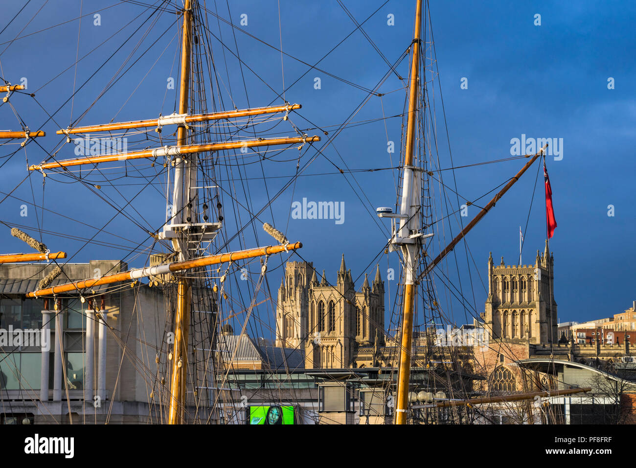 Bristol Cathedral - The Cathedral Church of the Holy and Undivided Trinity - framed by the masts of the Tall Ship Kaskelot, Bristol, England Stock Photo