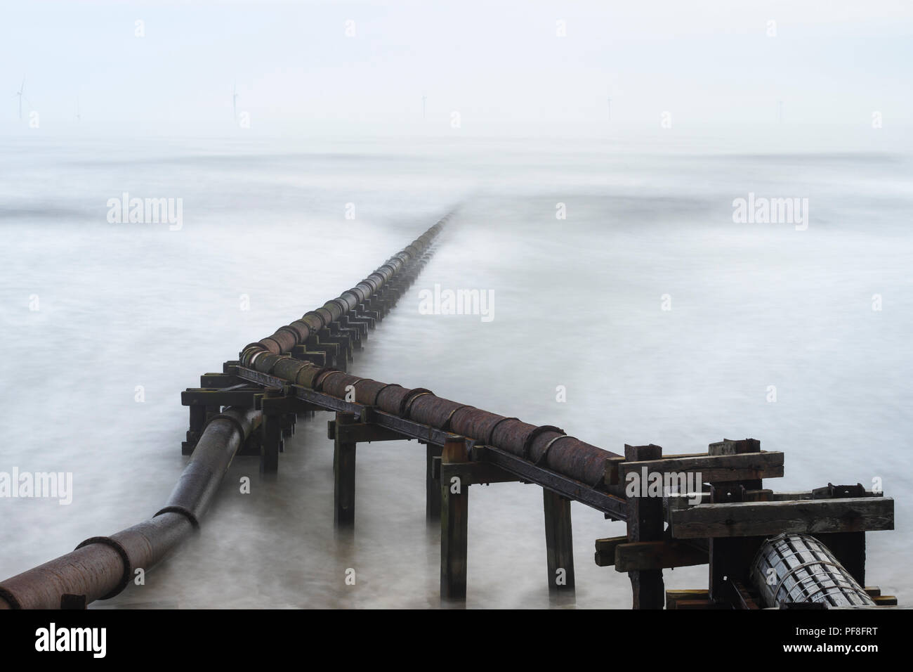 Long exposure image of a pipe running out to sea at Cambois on the Northumberland coast, England Stock Photo