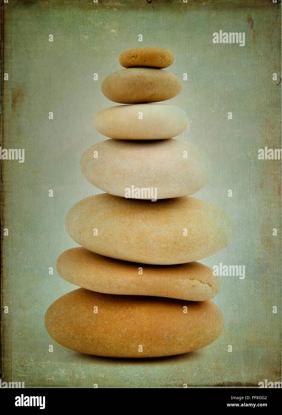 Parchment Rocks Vertical closeup of different sized rocks put in a tower on a parchment ...