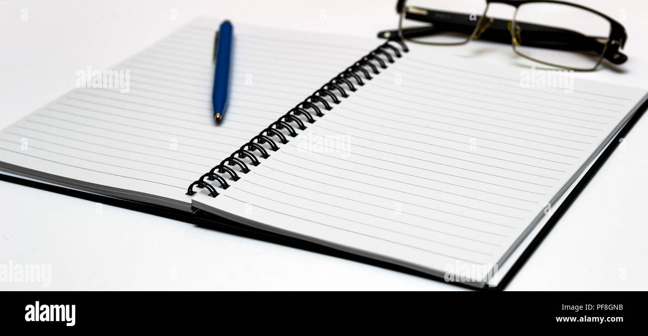 Notebook and glasses and red pen on table. White background Stock Photo