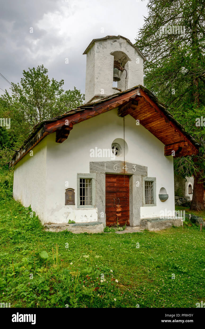 view of small mountain chapel, shot on a bright summer cloudy day at Tschaval, near Gressoney la Trinite,  Lys valley, Aosta, Italy Stock Photo