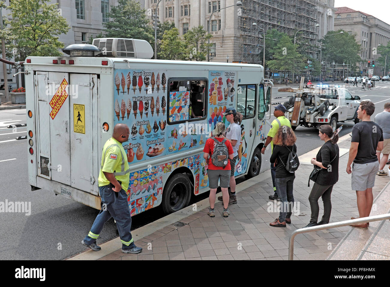 Hot weather in Washington DC in August draws people to the ice cream truck for cooling off. Due to its location, the truck is being cited and towed. Stock Photo