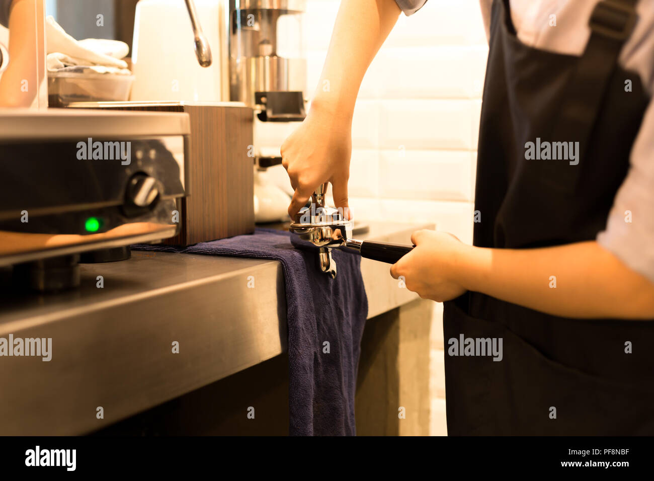Barista presses ground coffee using tamper  Stock Photo