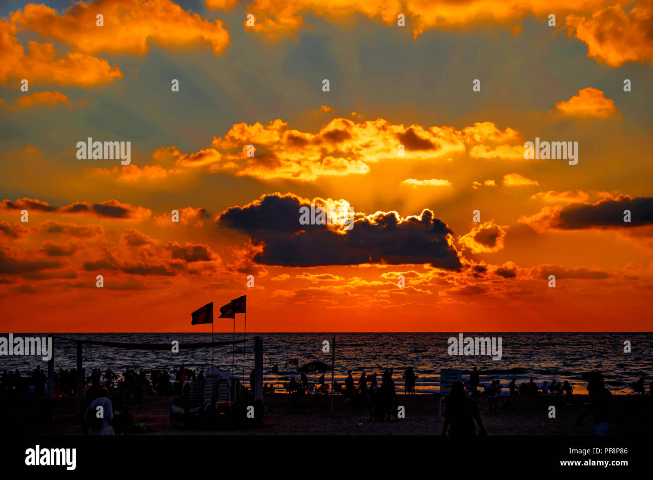 People on the beach during sunset on the Mediterranean Sea Stock Photo