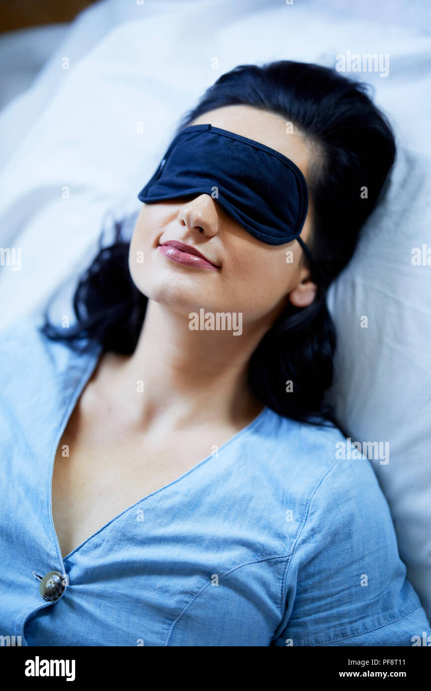 Woman sleeping wearing a mask Stock Photo