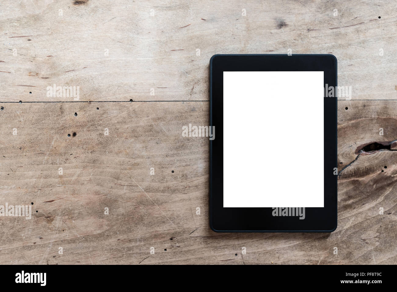 e-book reader or digital tablet on rustic wooden table Stock Photo