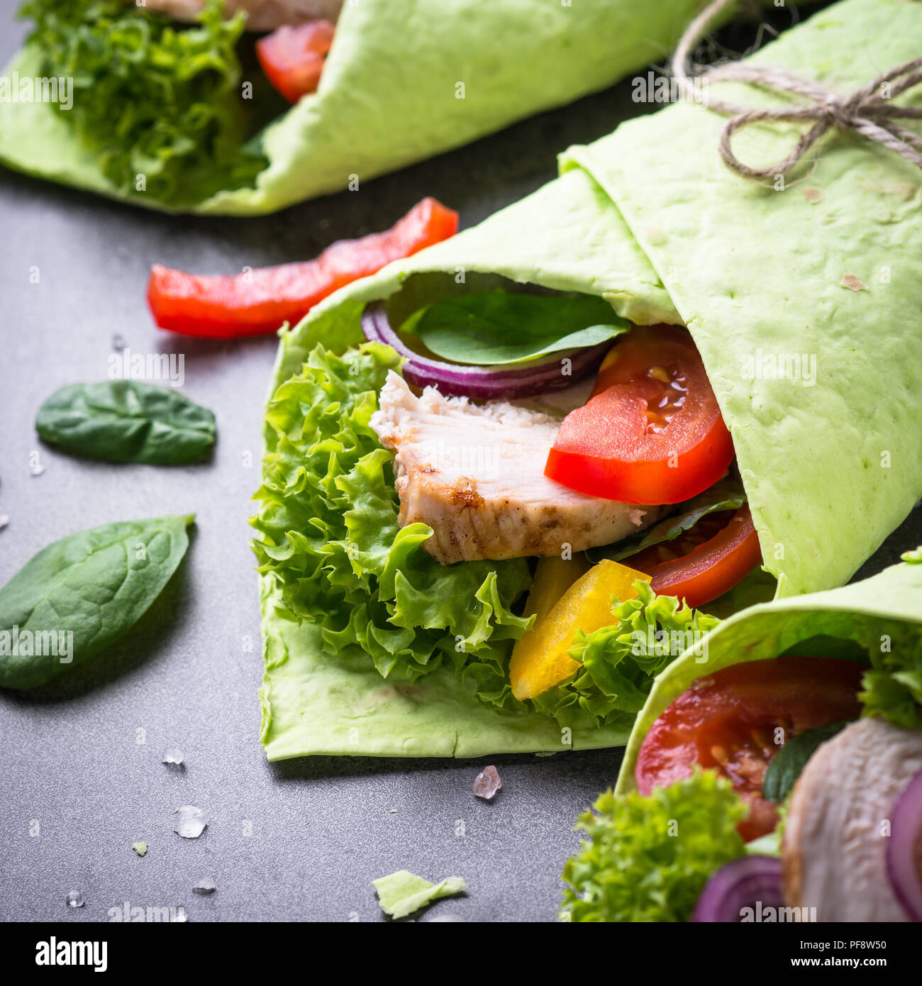 Green spinach tortilla with Chicken and vegetables. Healthy snack. Close up. Stock Photo