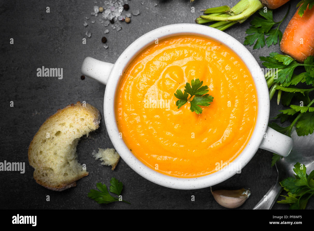 Carrot cream-soup on black table. Vegetarian vegetables soup. Top view. Stock Photo