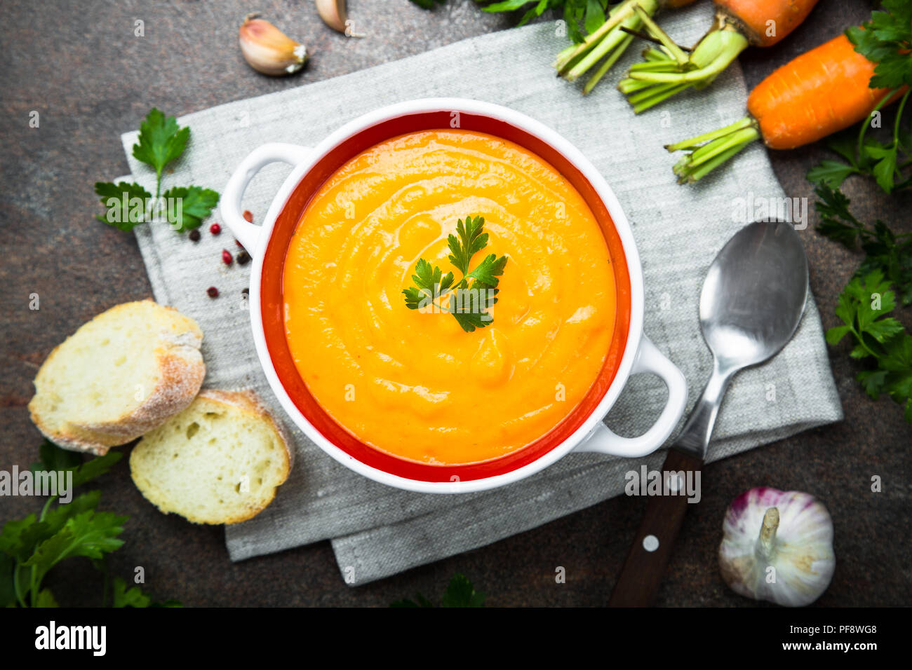Carrot pumpkin cream-soup on dark stone table. Vegetarian vegetables soup. Top view. Stock Photo