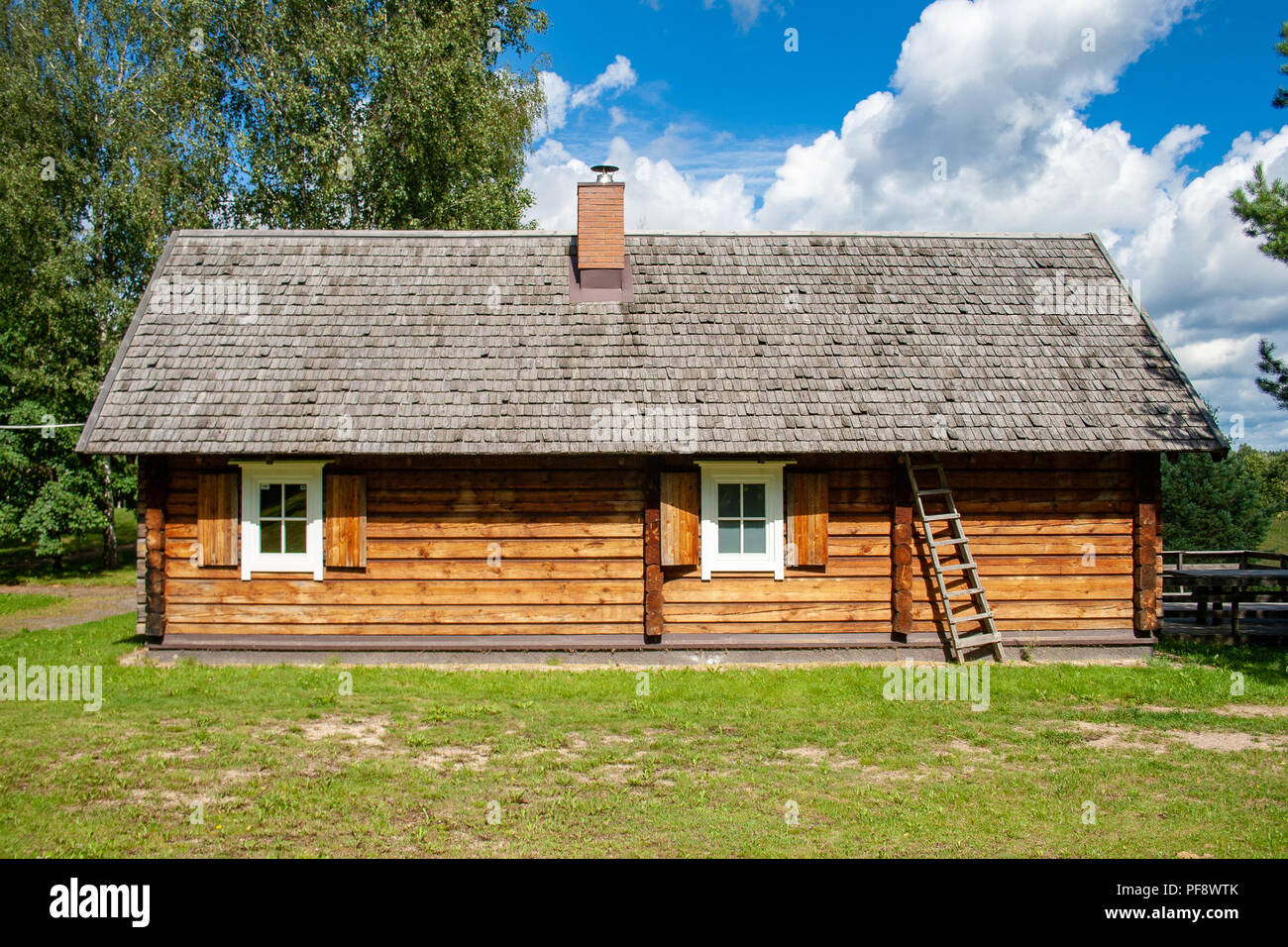 Old lithuanian wooden house in Vilnius, Lithuania with sky and nature Stock Photo