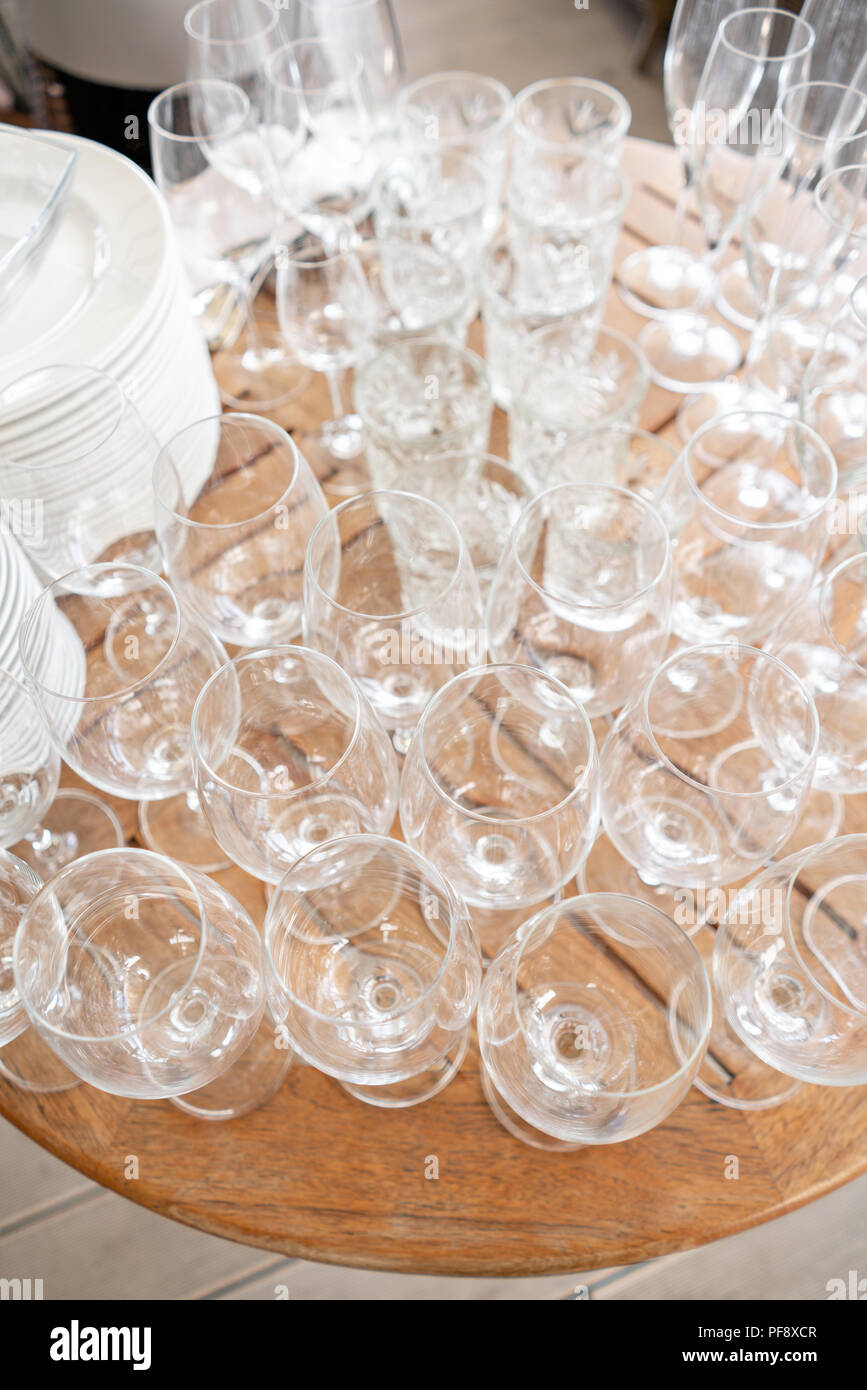 Clean plates, glasses and cutlery on wooden table. Catering set-up ready for the event to begin. ervice area the waiter in restaurant. Stock Photo