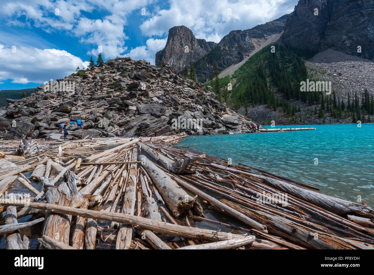Banff, Canada--August 6, 2018.  Wide angle shot of tourists climbing on a rock pile by Moraine Lake. Stock Photo