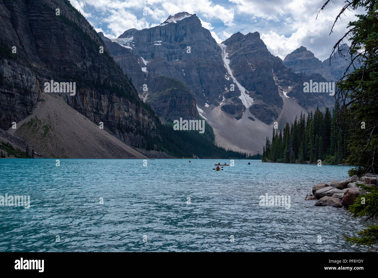 Banff, Canada--August 6, 2018.  Wide angle shot of boaters in kayaks  and canoes on Moraine Lake on a sunny summer afternoon. Stock Photo