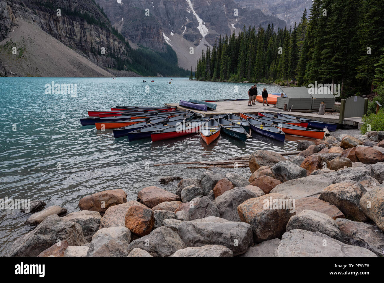 Banff, Canada--August 6, 2018.  Wide angle shot of a small pier at Moraine Lake where tourists rent canoes and kayaks to go boating. Stock Photo