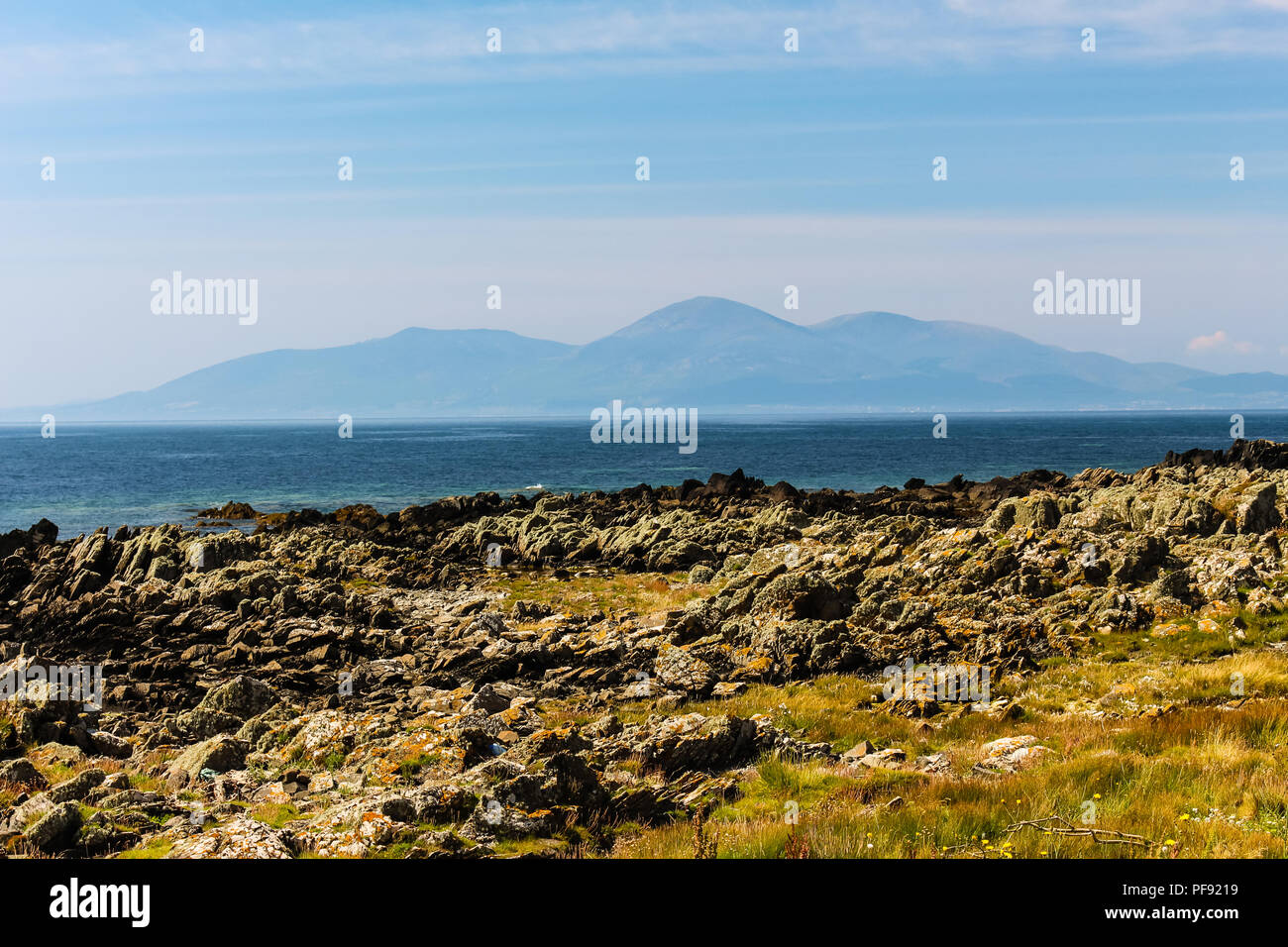 View from St John's Point over the rocky coastline and sea to the Mourne Mountains, N.Ireland. Stock Photo