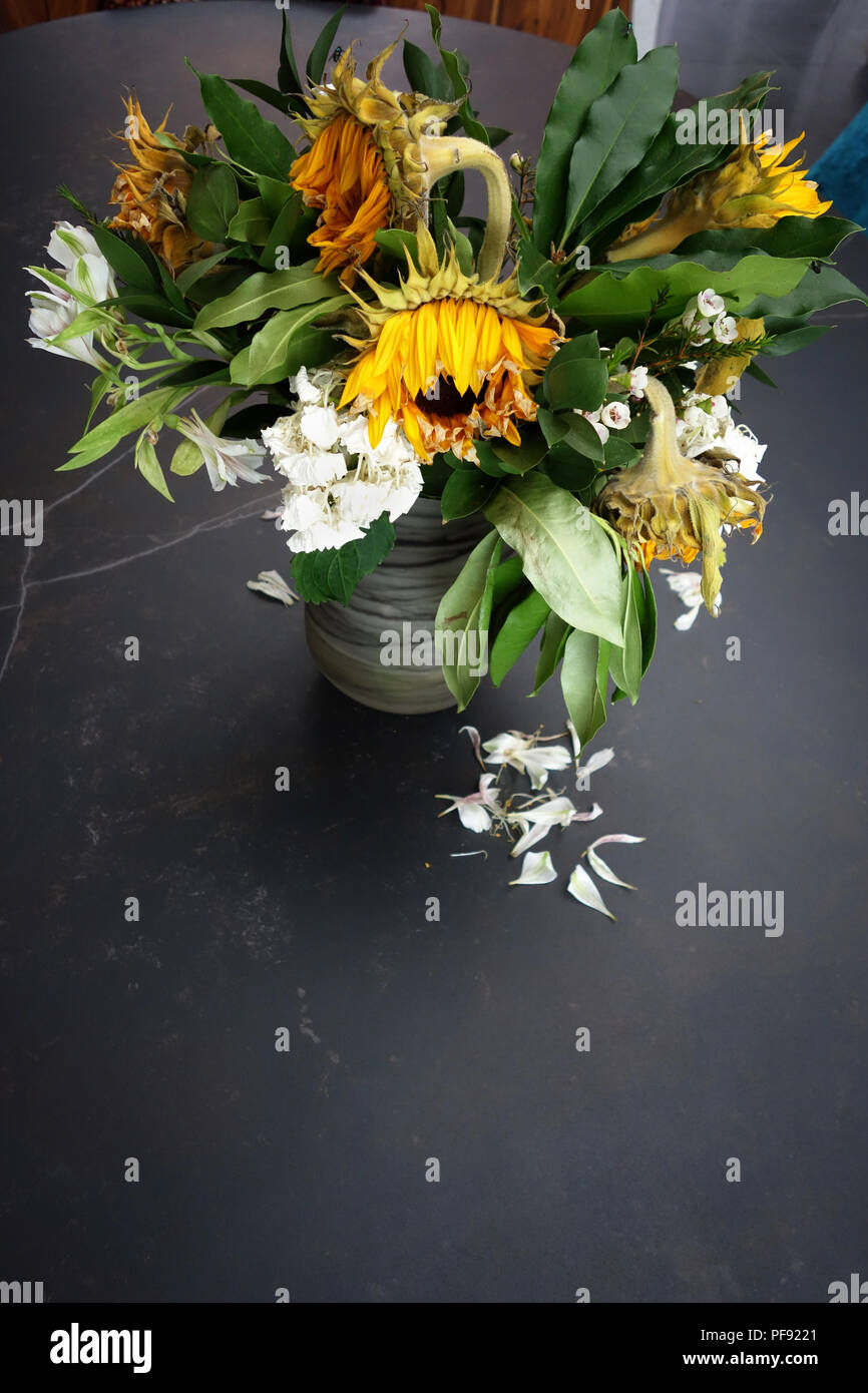 Looking slightly down at a vase of dying flower arrangement, large once