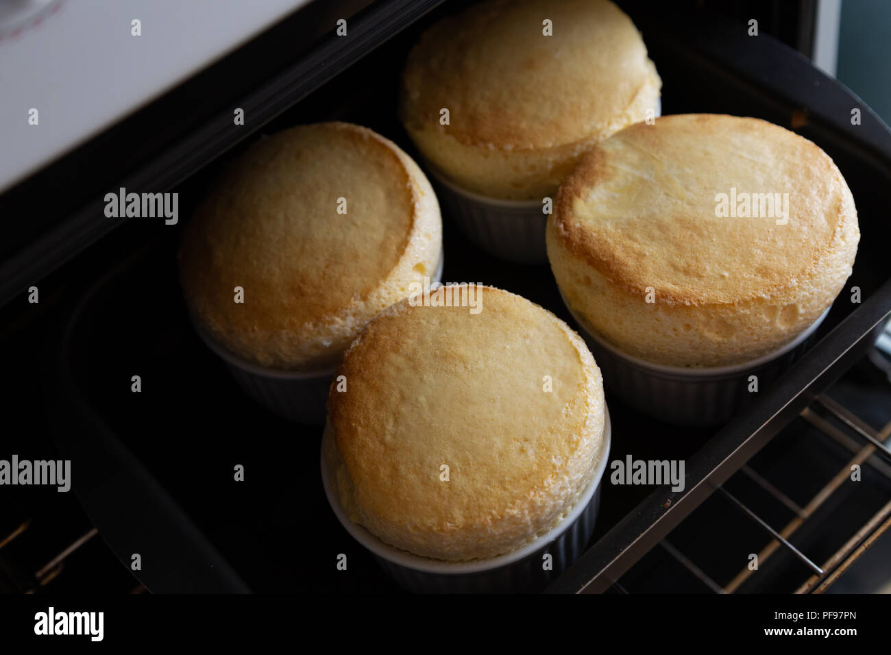Four soufflés in white ceramic bowl (ramekin) on oven, homemade Stock